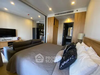 Modern bedroom with stylish decor and open layout, featuring a cozy bed and sleek furniture.