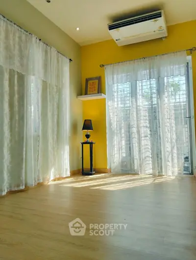 Bright living room with large windows and wooden flooring