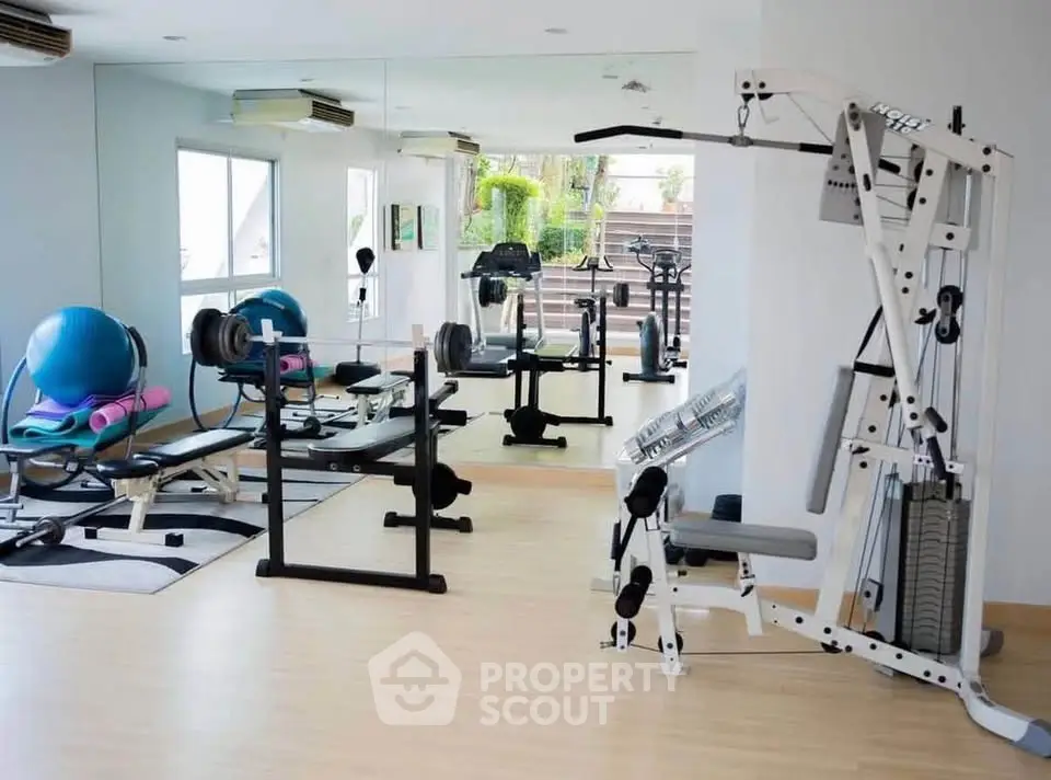 Modern gym with state-of-the-art fitness equipment and mirrored walls in a residential building.