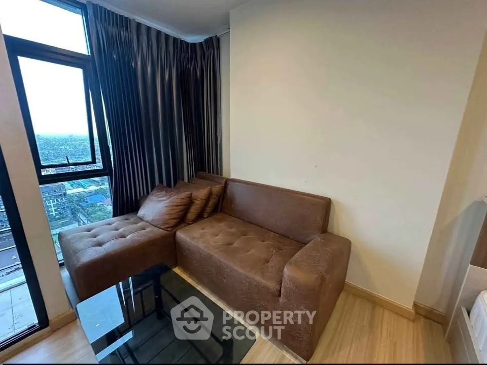Cozy living room with brown sectional sofa and city view from large window.