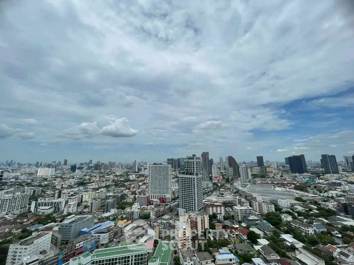 Stunning cityscape view from a high-rise building showcasing urban skyline under a cloudy sky.