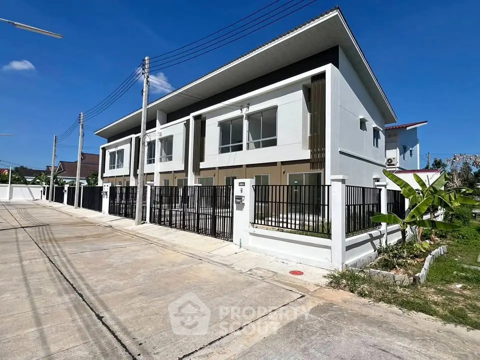 Modern duplex with sleek design and spacious driveway in a sunny neighborhood.