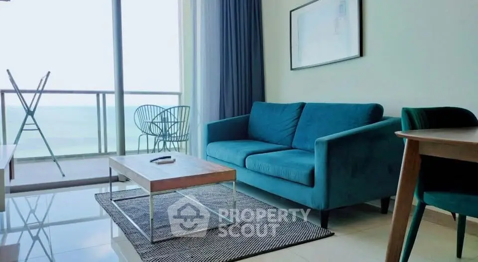 Modern living room with ocean view, stylish furniture, and floor-to-ceiling windows.