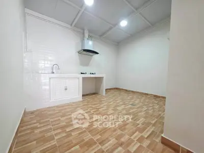 Spacious kitchen with modern gas stove and ample storage in a bright, tiled interior.