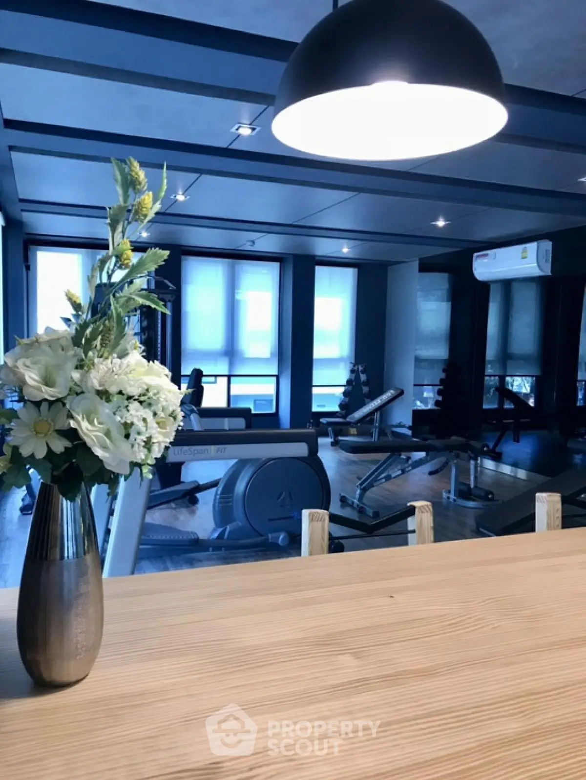 Modern gym with exercise equipment and stylish decor in luxury real estate property.