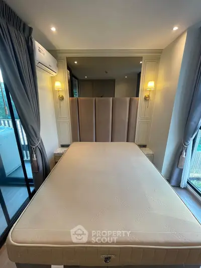 Modern bedroom with elegant decor and large windows offering natural light and a cozy atmosphere.
