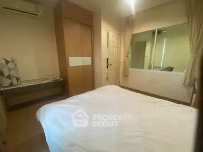 Cozy bedroom with modern design, featuring a large bed, built-in wardrobe, and air conditioning.
