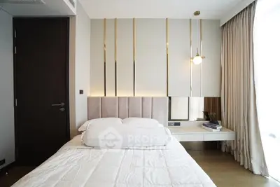 Modern bedroom with elegant decor and natural light, featuring a cozy bed and stylish wall accents.