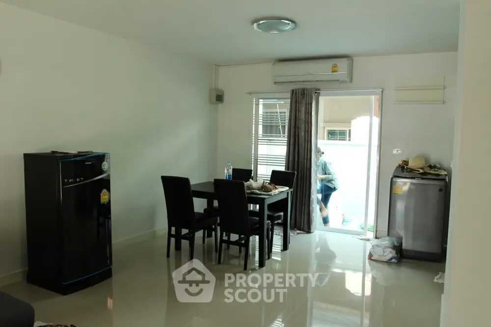 Modern dining area with sleek furniture and appliances in a bright, open space.