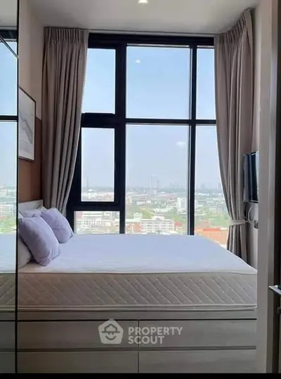 Modern bedroom with large windows offering stunning city views