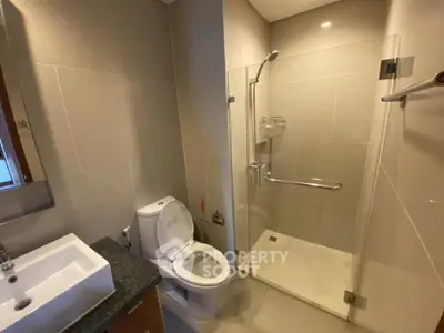 Modern bathroom with glass shower and sleek fixtures in a contemporary home.
