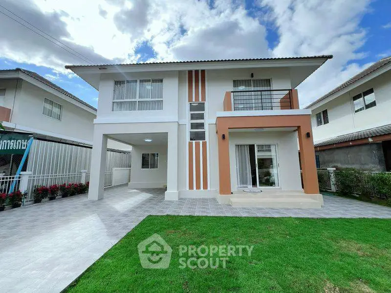 Modern two-story house with spacious driveway and lush green lawn under a clear blue sky.