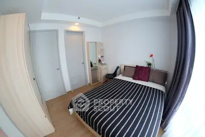 Cozy bedroom with modern decor and ample natural light, featuring a stylish bed and wardrobe.
