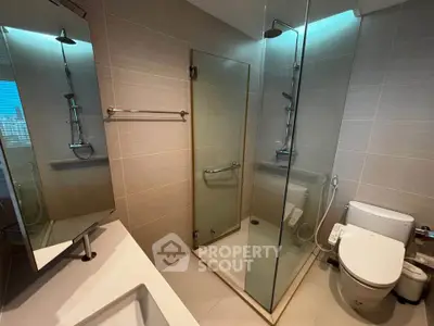 Modern bathroom with glass shower and sleek fixtures in a contemporary apartment.