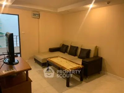 Cozy living room with modern sofa and TV, perfect for relaxation.