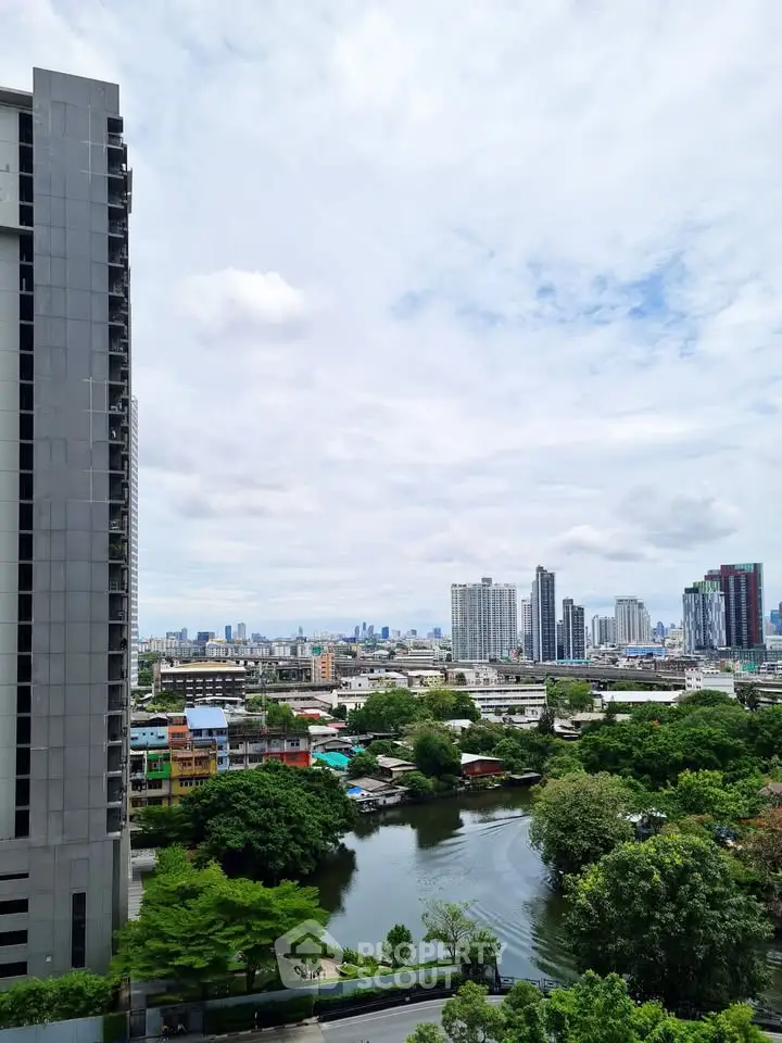 Stunning cityscape view from high-rise building with lush greenery and river below.