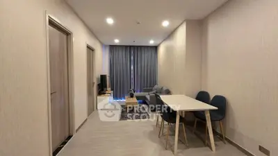 Modern living room with cozy seating and dining area, featuring elegant decor and natural lighting.