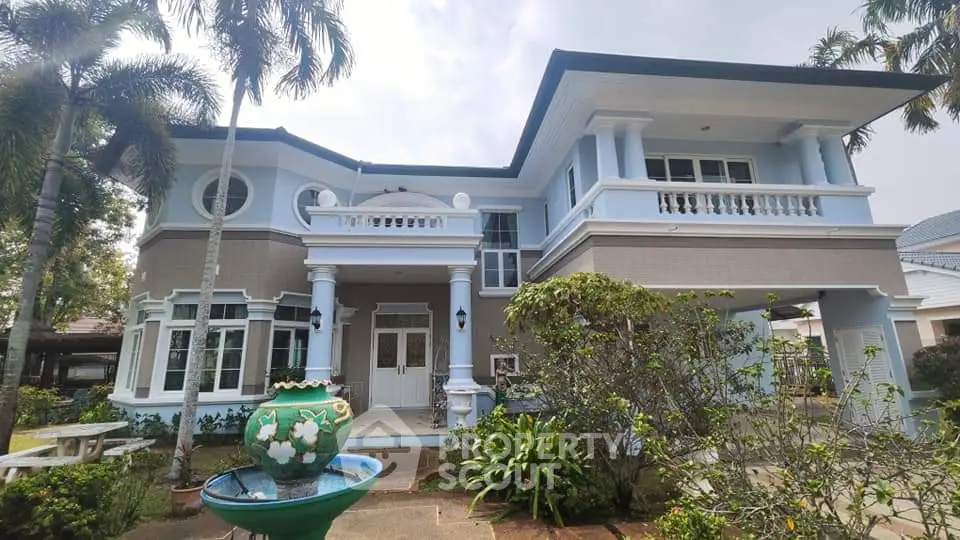 Stunning two-story home with elegant columns and lush garden in a serene neighborhood.