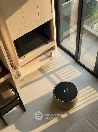 Modern living room with large windows and sleek furniture, offering abundant natural light and a cozy atmosphere.