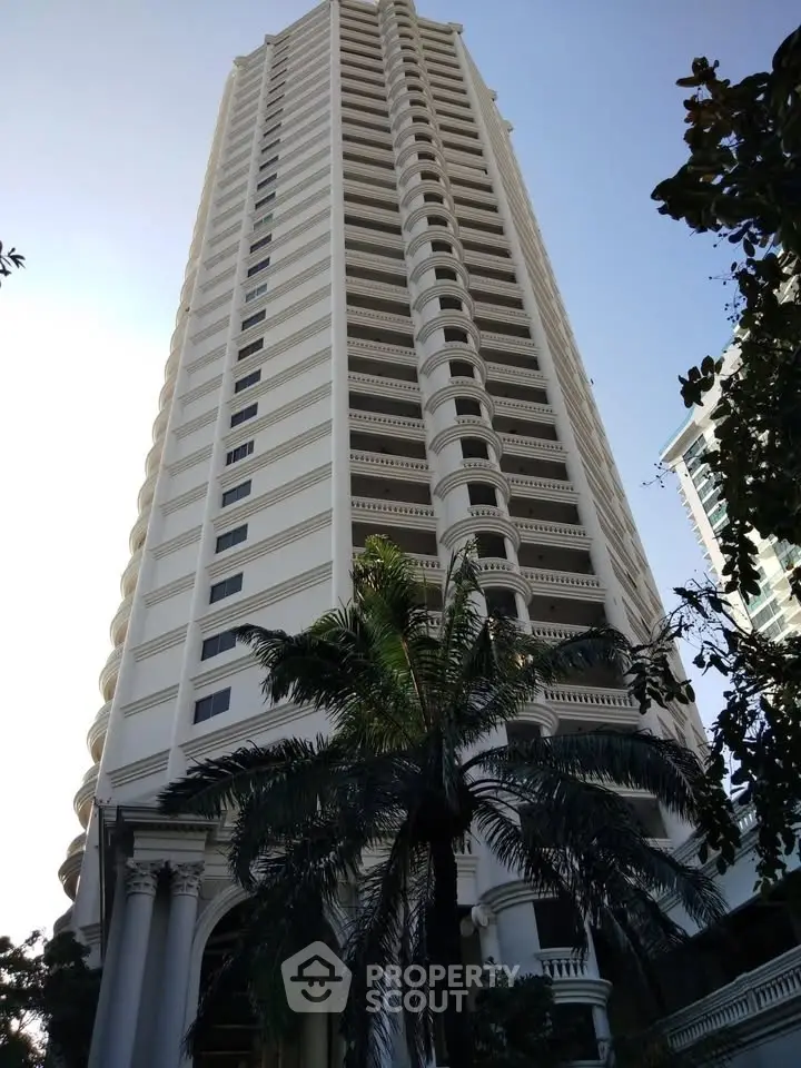 Stunning high-rise building with elegant architecture and lush palm trees, perfect for luxury urban living.