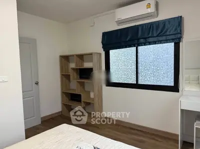 Cozy bedroom with air conditioning and stylish wooden shelving