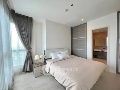 Modern bedroom with elegant decor and ensuite bathroom in luxury apartment.