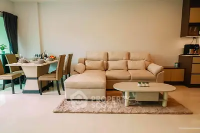 Modern living room with cozy beige sofa and elegant dining area in open layout apartment.