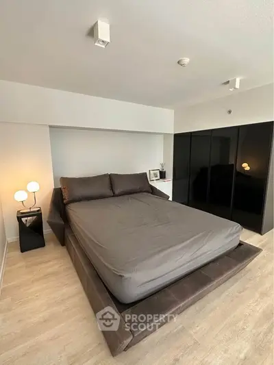 Modern bedroom with sleek design, featuring a stylish bed and contemporary lighting, perfect for urban living.
