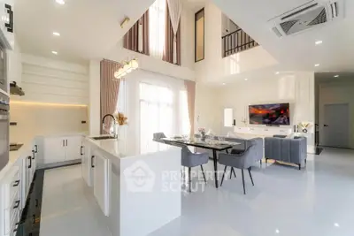 Luxurious open-plan living room with high ceilings and modern kitchen in elegant home.