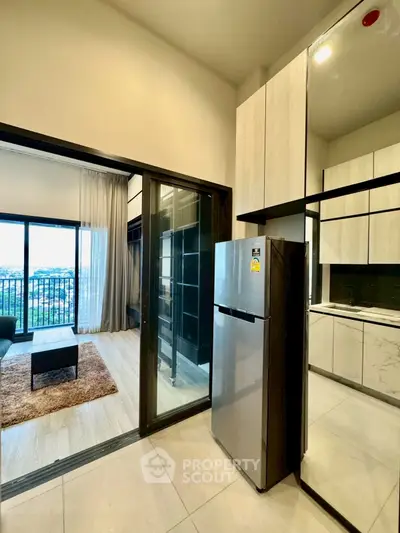 Modern apartment with open kitchen and spacious living area featuring large windows and a cozy rug.