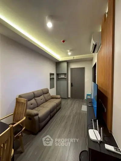 Modern living room with sleek design, featuring a comfortable sofa and entertainment setup.