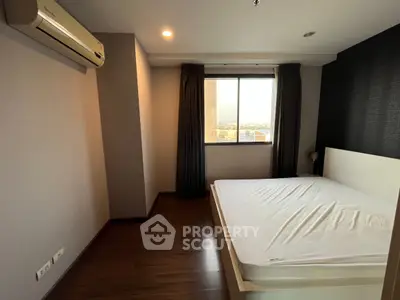 Spacious bedroom with large window and modern air conditioning unit, offering a cozy and comfortable living space.