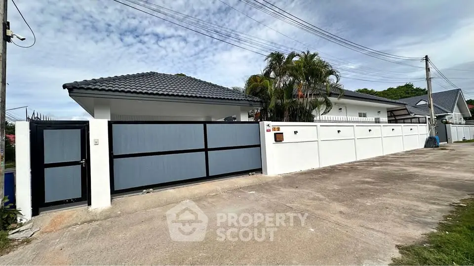 Charming suburban home with modern fence and lush greenery, perfect for family living.