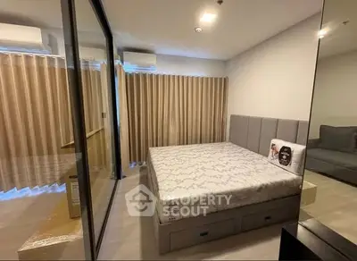 Modern bedroom with large mirrored wardrobe and stylish bed in a cozy apartment.
