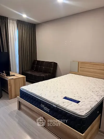 Modern bedroom with stylish furniture and natural light, featuring a comfortable bed and sleek decor.
