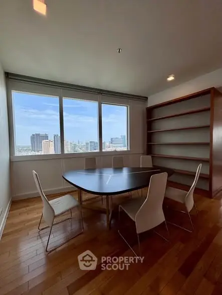 Spacious study room with city view, featuring modern table and chairs, ideal for work or meetings.