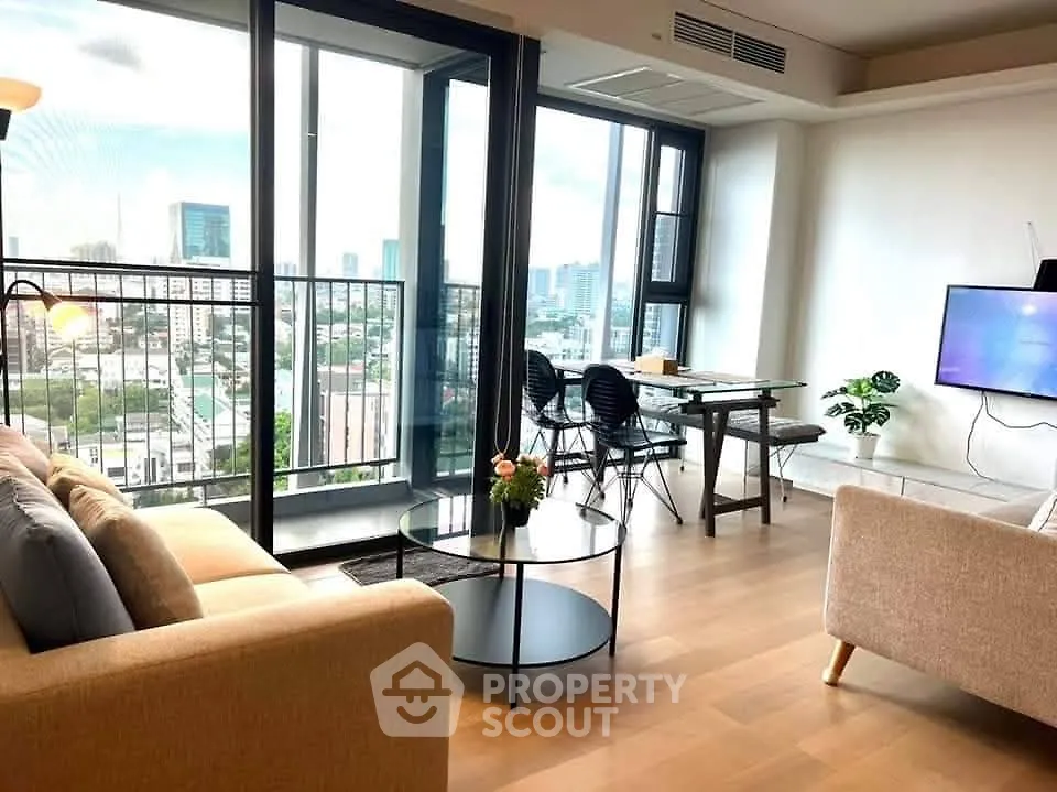 Modern living room with city view and stylish furniture in high-rise apartment.
