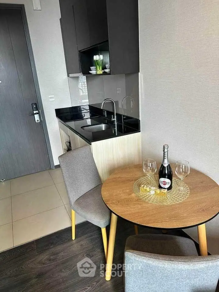 Modern compact kitchen with dining area, featuring sleek cabinetry and stylish decor.