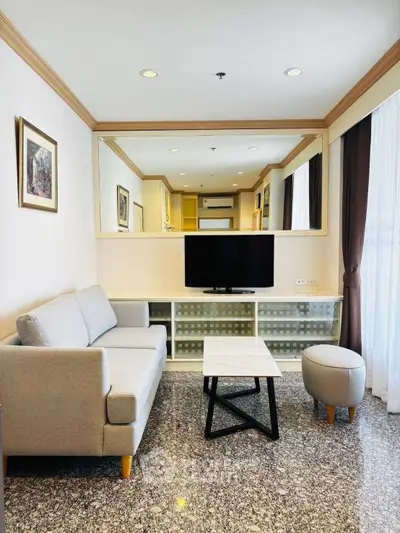 Chic modern living room with stylish sofa, TV, and elegant decor in a cozy apartment setting.