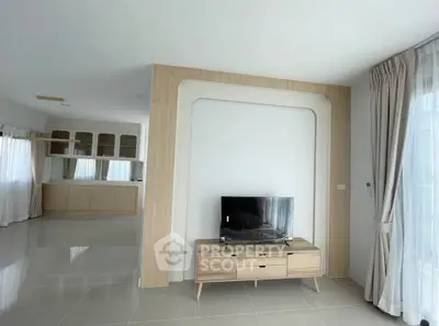 Spacious modern living room with sleek TV stand and open layout kitchen