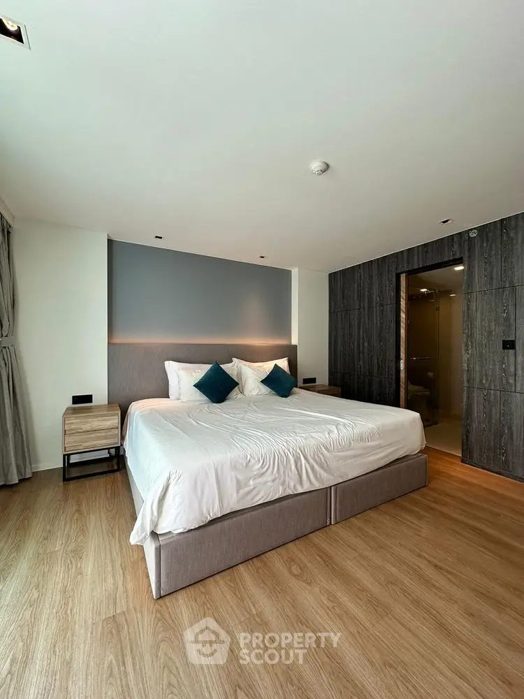 Modern bedroom with stylish decor and ensuite bathroom in luxury apartment.