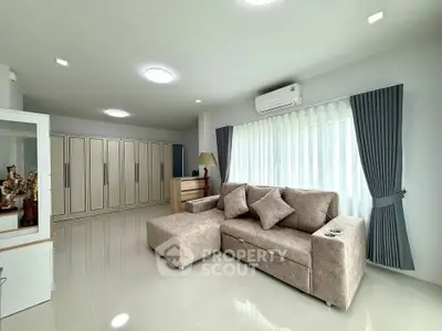 Spacious modern living room with elegant furniture and ample natural light.