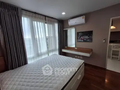 Modern bedroom with large windows and air conditioning in stylish apartment