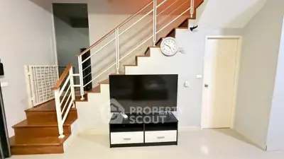 Modern interior with stylish staircase and sleek TV setup in a contemporary home.