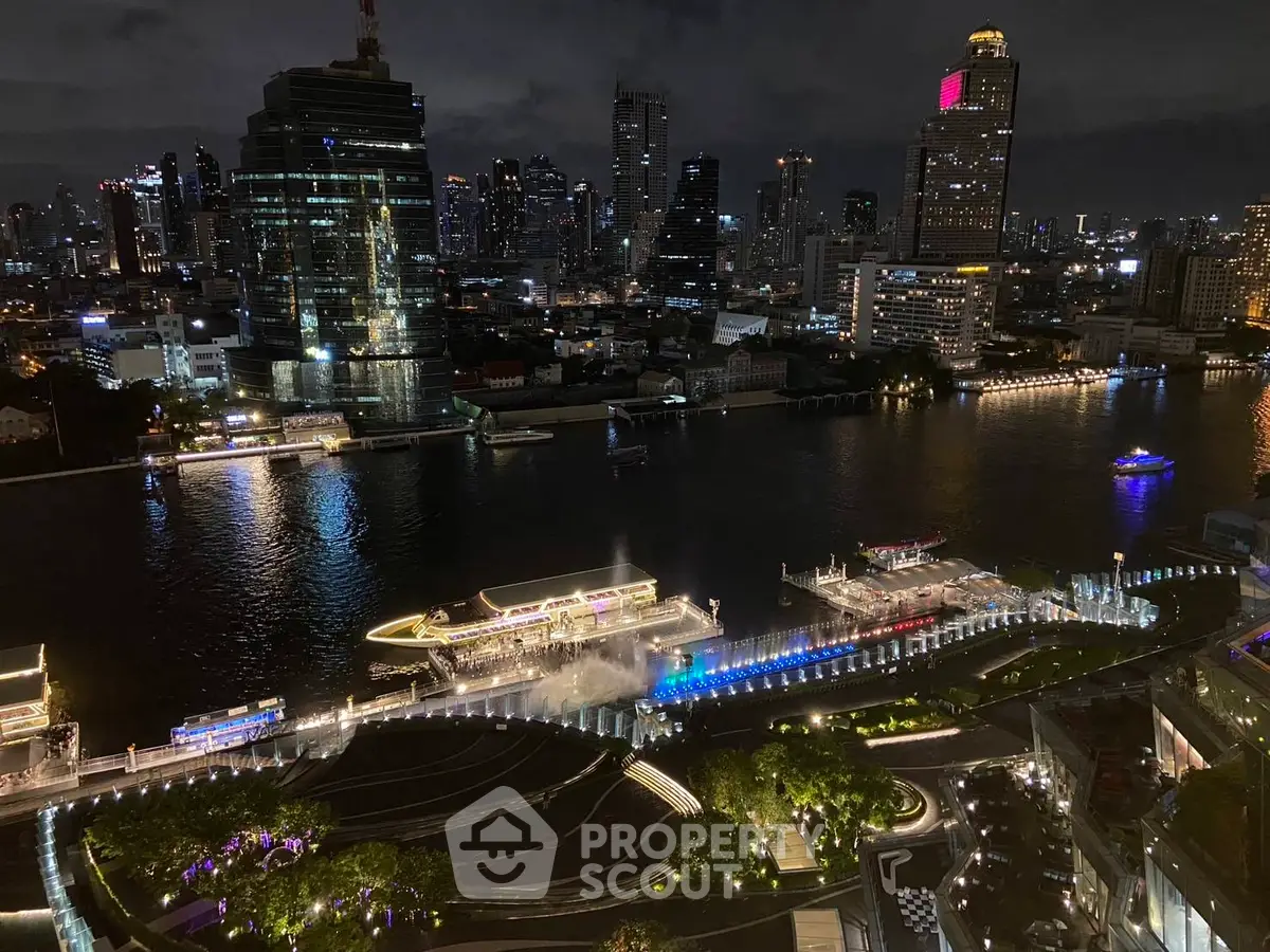 Stunning night view of a city skyline with illuminated waterfront and modern buildings.