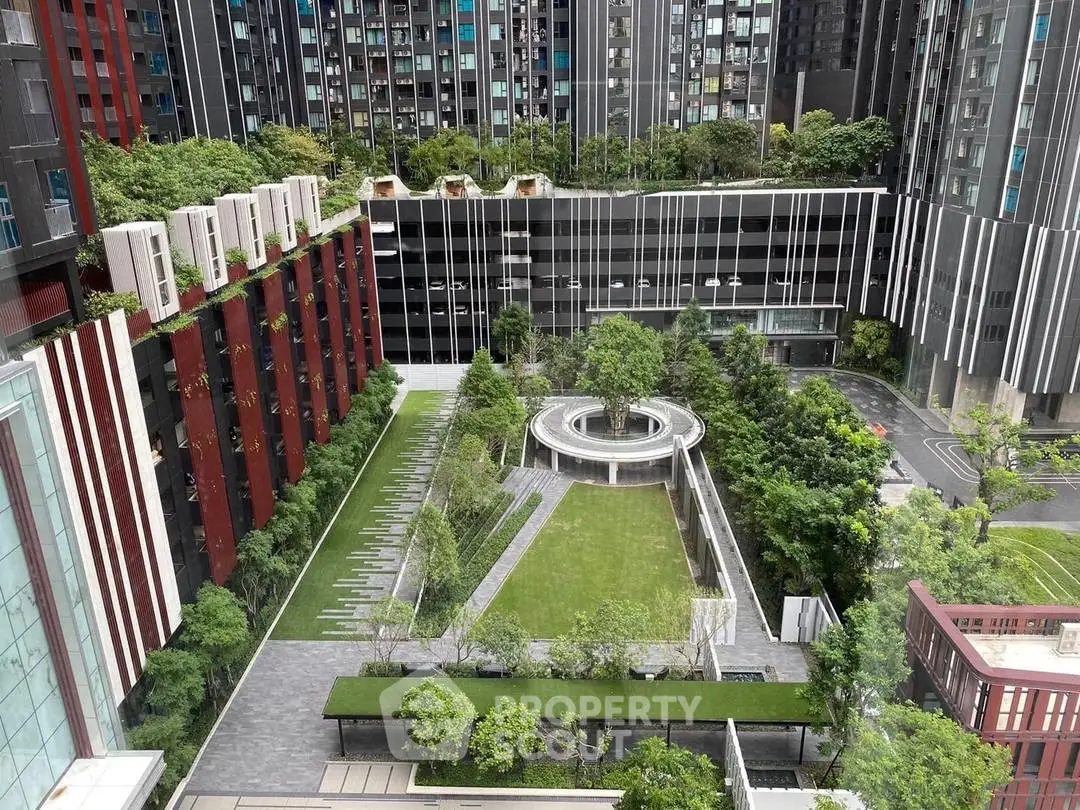 Modern urban garden with lush greenery and sleek architectural design in a residential complex.