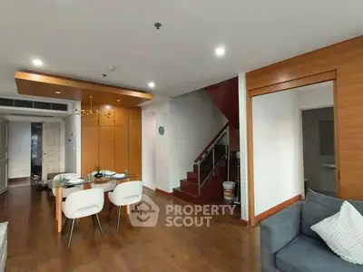 Modern living room with dining area and staircase in stylish apartment