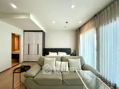 Modern living room with cozy sofa and large windows in a stylish apartment.