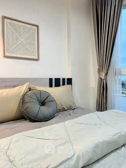 Cozy bedroom with elegant decor and large window offering natural light and serene views.
