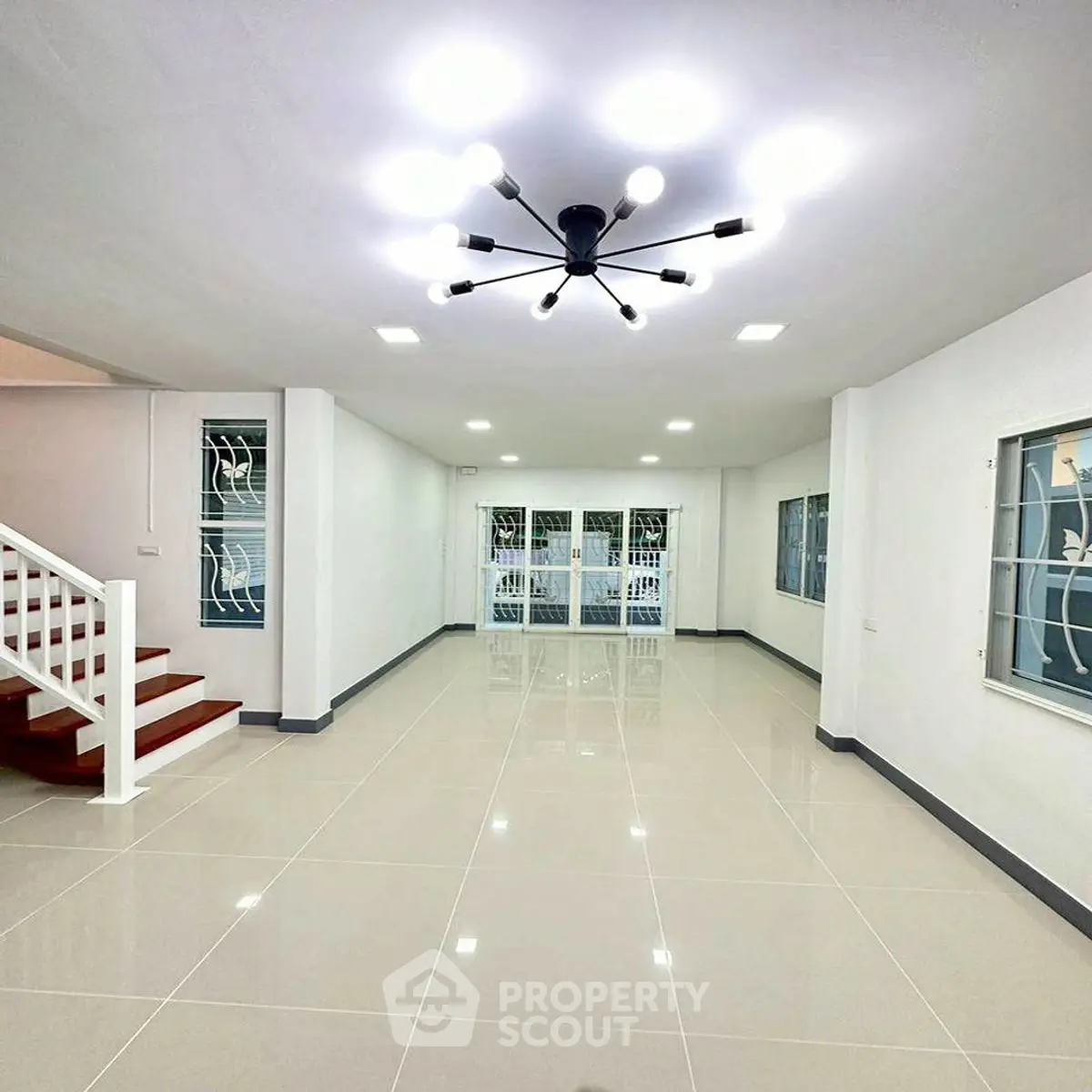 Spacious modern living room with elegant lighting and glossy tile flooring